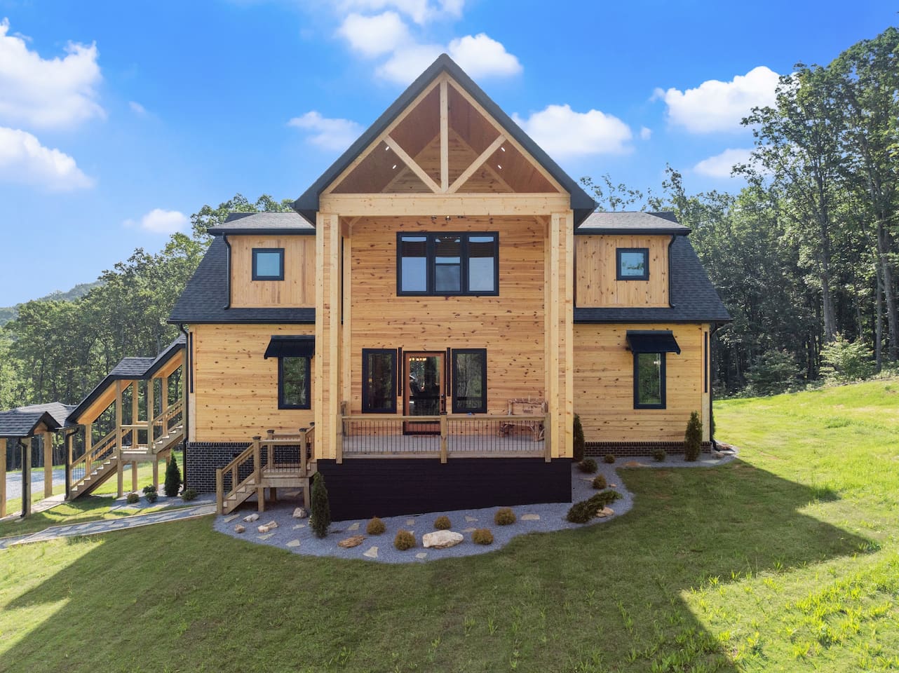 This front-facing shot captures the cabin’s dramatic A-frame design and inviting covered porch area.