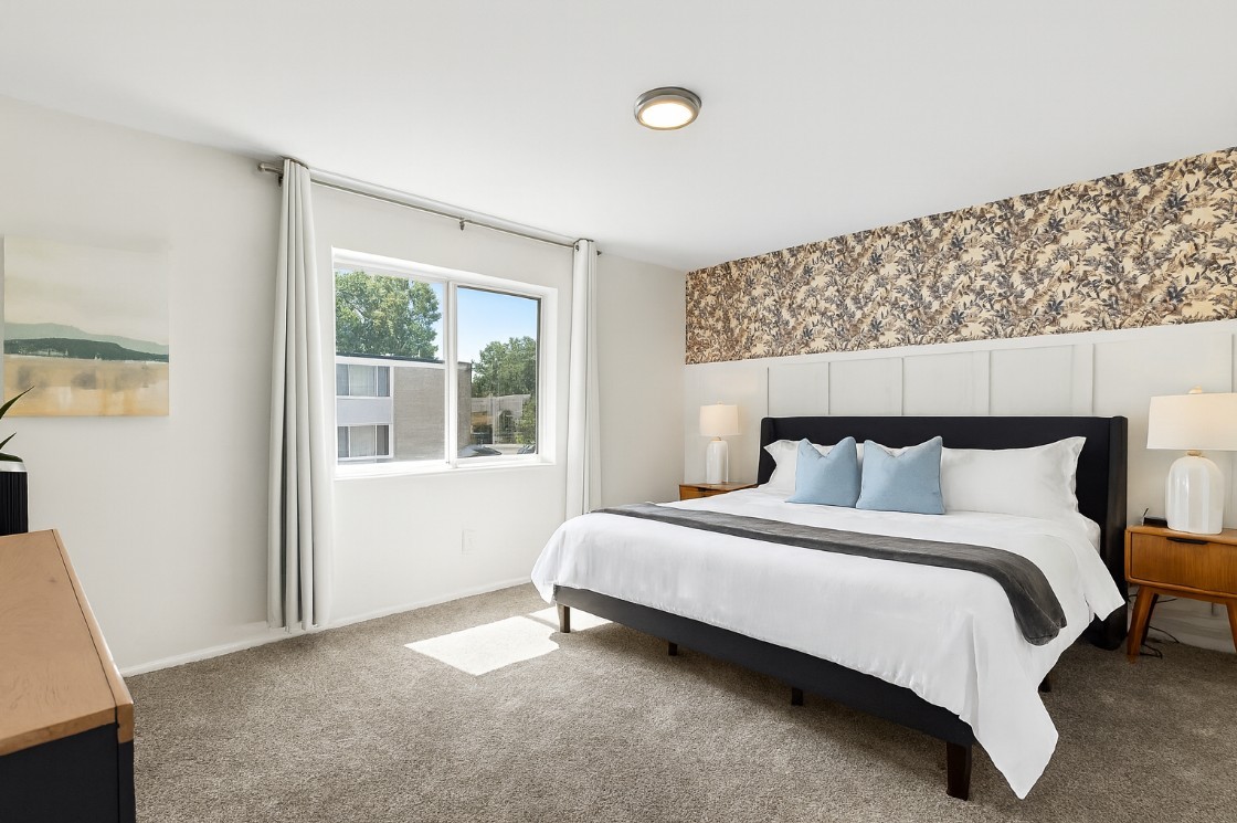 Bright and airy bedroom with large windows, a king bed, and modern art for a peaceful vibe.