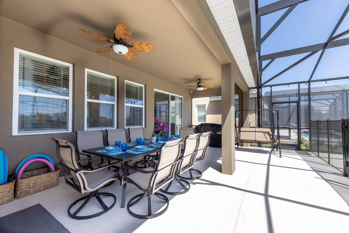 Outdoor seating area with 8 chairs, overhead fans, double grill BBQ and 2 person swing. 