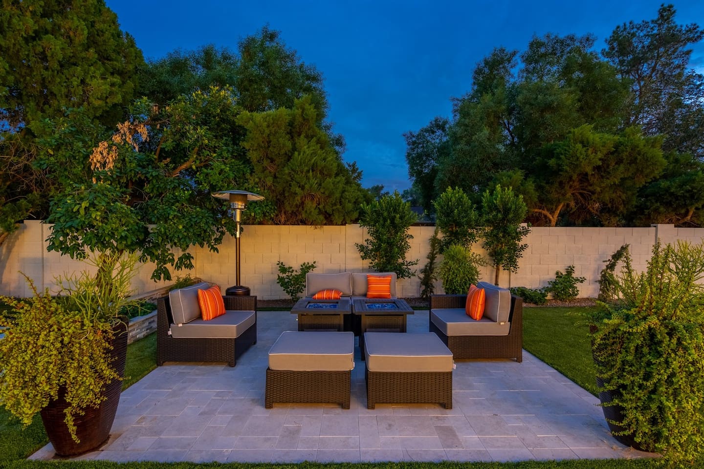 Experience unparalleled comfort on our outdoor sofa lounge, featuring soft throw pillows and a cozy fireplace. This serene setting offers a tranquil view of the pool and surrounding trees, perfect for unwinding after a long day.