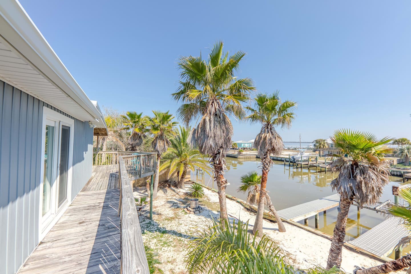Deck with a View: Enjoy stunning waterfront sights and palm-fringed sunsets in Fort Morgan!