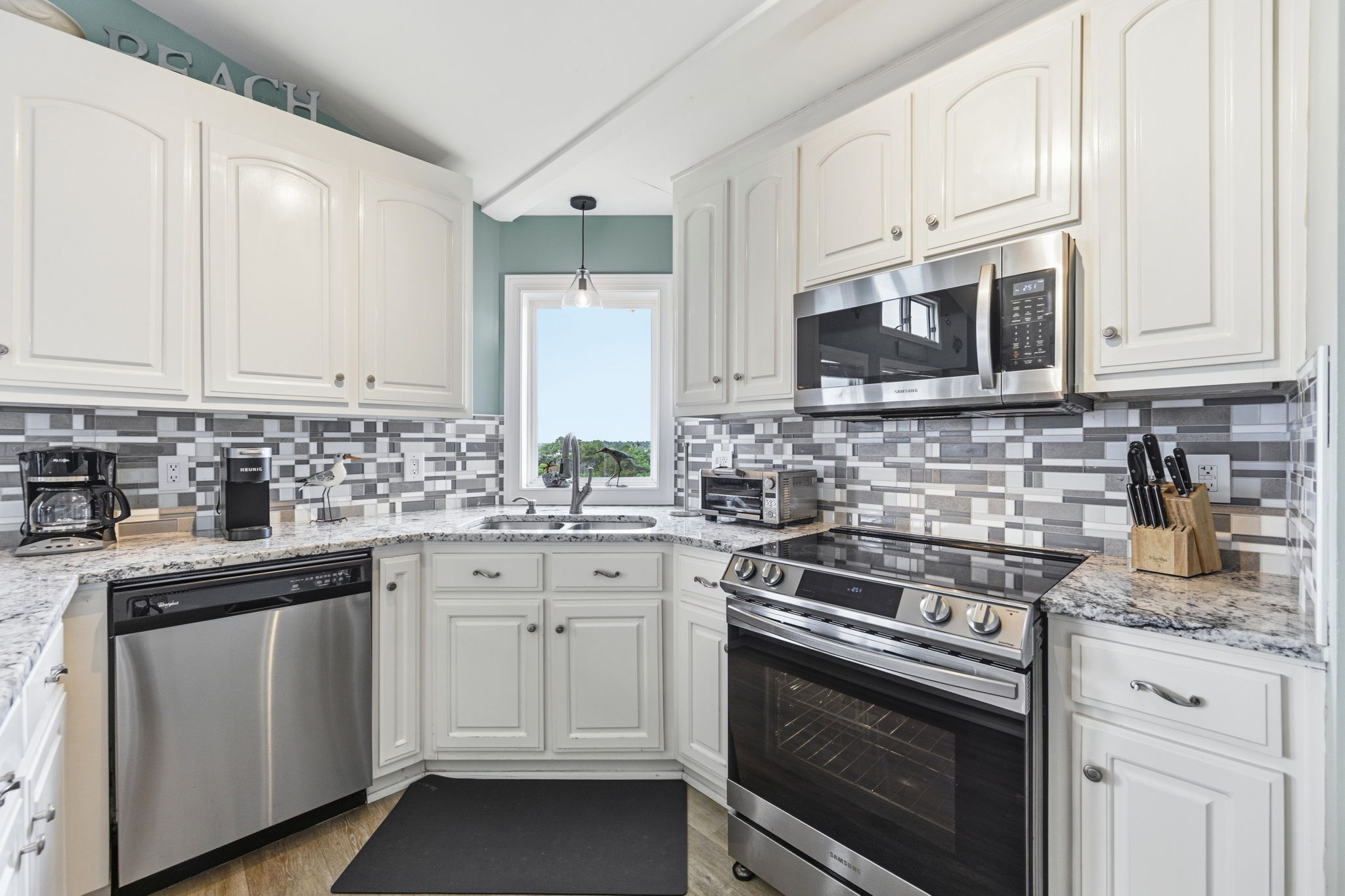 Granite countertops, white cabinetry and updated appliances create a fresh, airy feel. Both single serve and traditional drip pot are provided