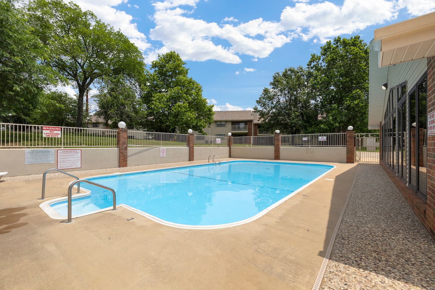 Pool Paradise: Splash into fun at our sparkling pool, surrounded by lush greenery and blue skies!