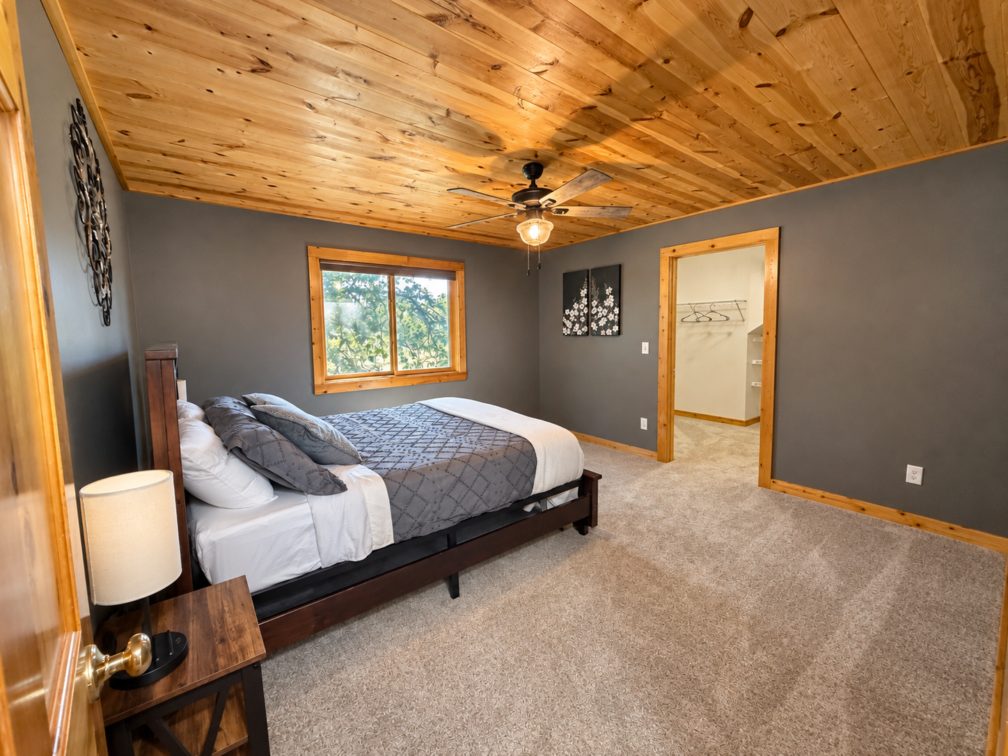 Warm wood ceilings and rustic finishes give this private bedroom a comfortable Northwoods feel. This spacious bedroom has a large walk in closet and room to spread out.