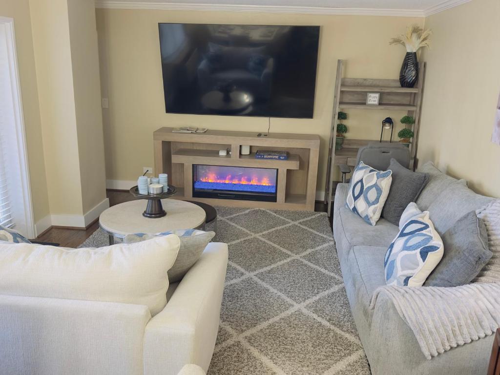 The sitting room features a comfortable seating area, a stylish display fireplace, and a large-screen TV—perfect for relaxing and unwinding.
