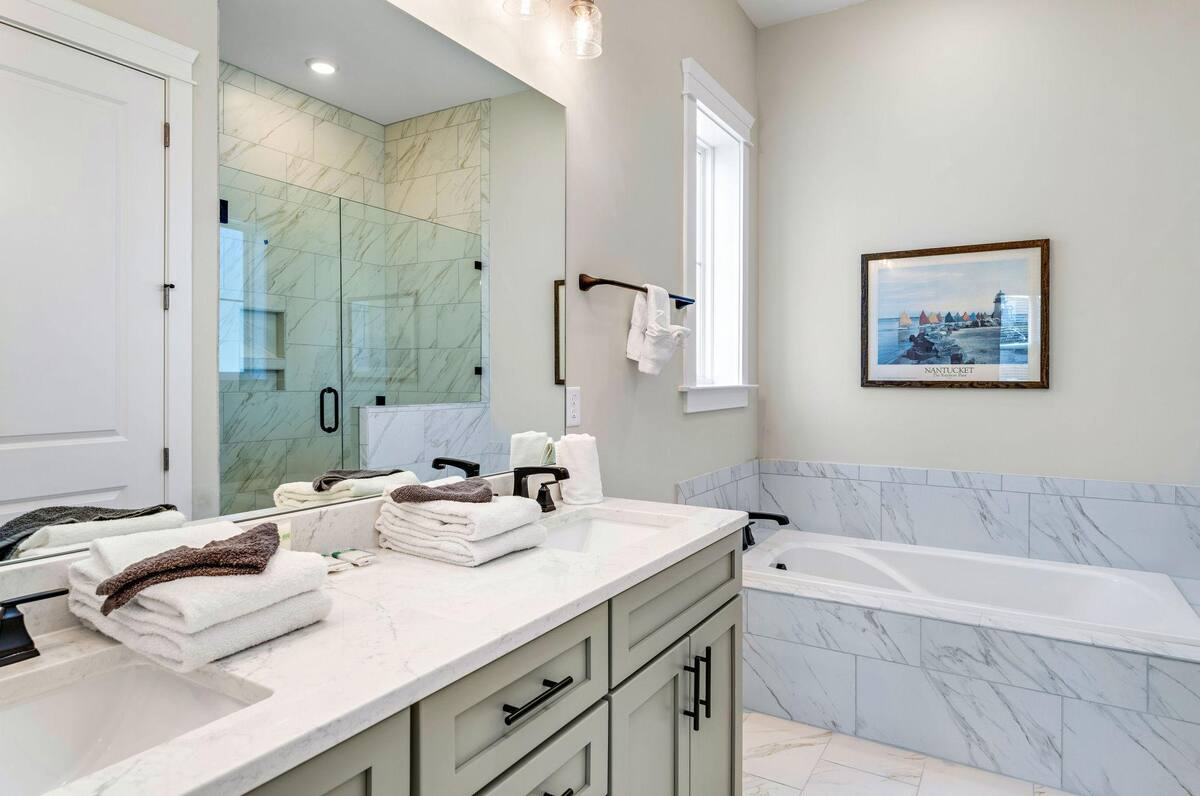 Indulge in the spa-like attached bath featuring a double vanity, deep soaking tub, walk-in shower, and a private water closet for added comfort.
