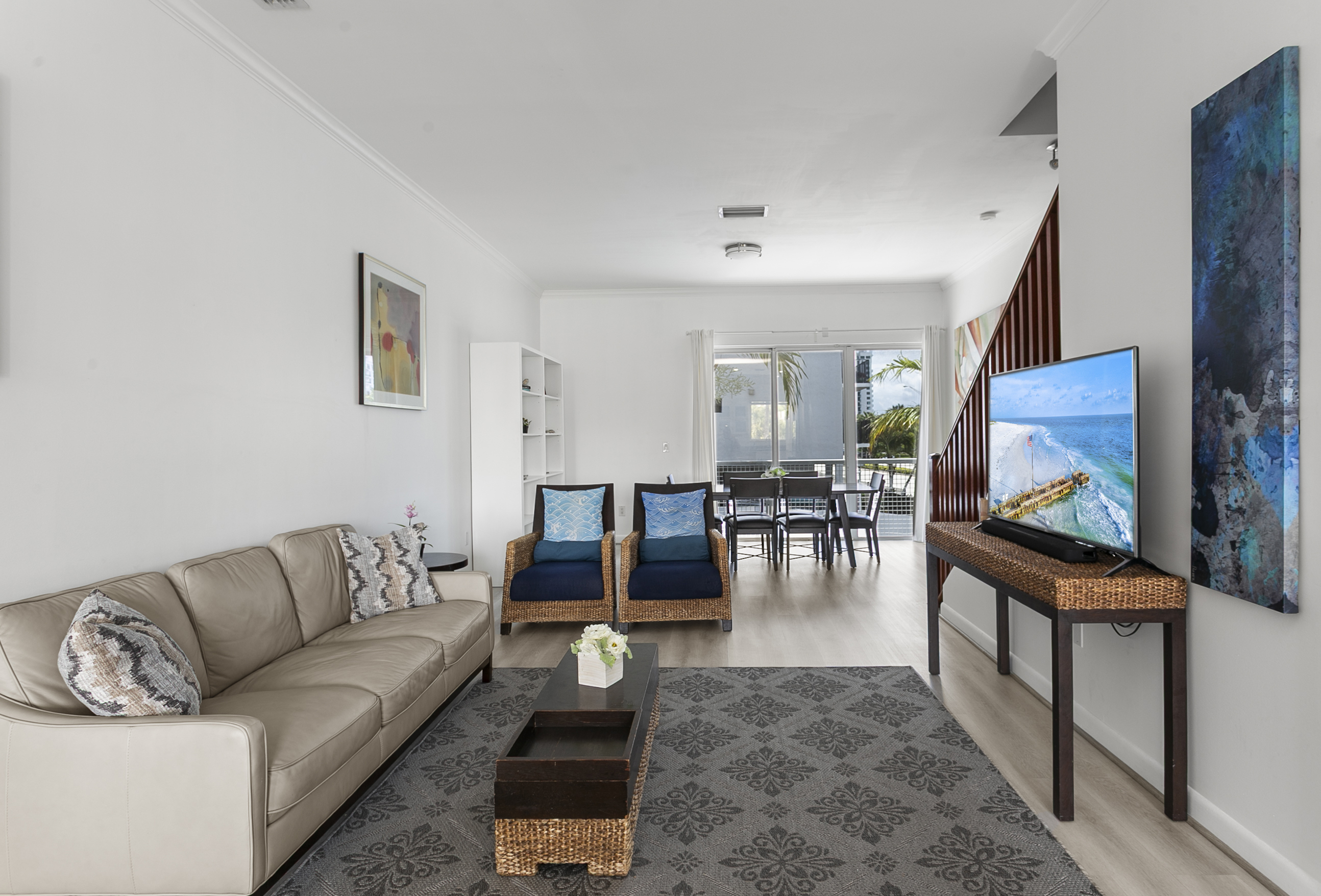 Living room with leather sofa, accent chairs, and a 50-inch flat screen TV.