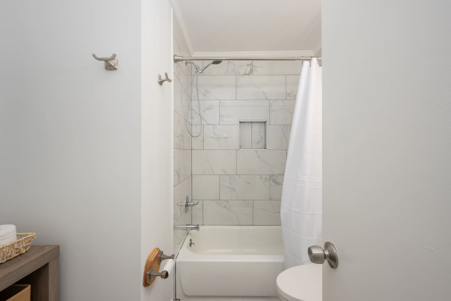 Bathroom with new tile shower, vanity, fixtures, and additional storage space.