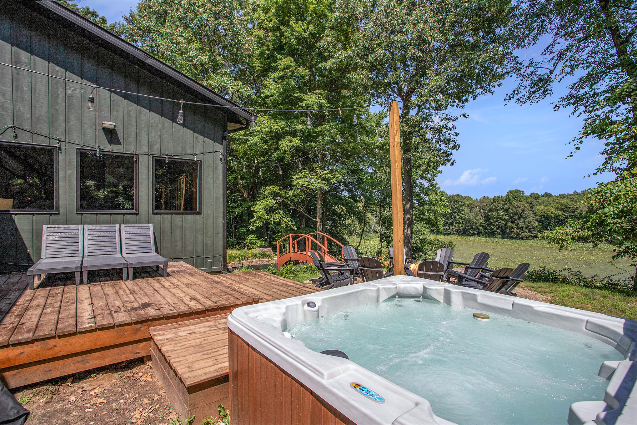 Private hot tub on the rear deck overlooking the pond and wooded grounds.