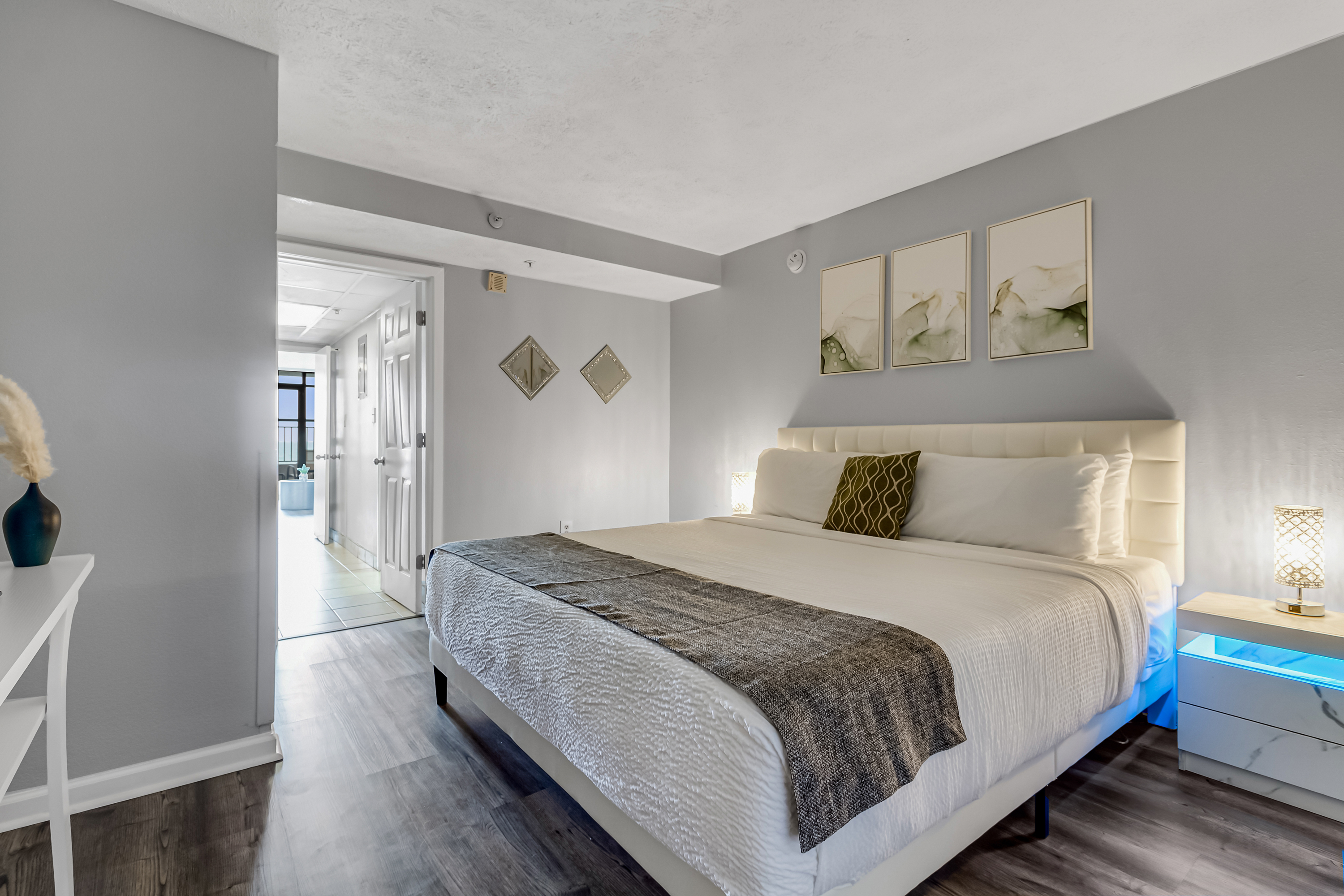 Relax in a spacious and elegantly decorated bedroom with plush bedding and soothing coastal tones.