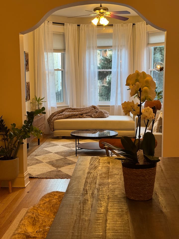 Bright living room with cozy seating and large windows bringing in natural light.