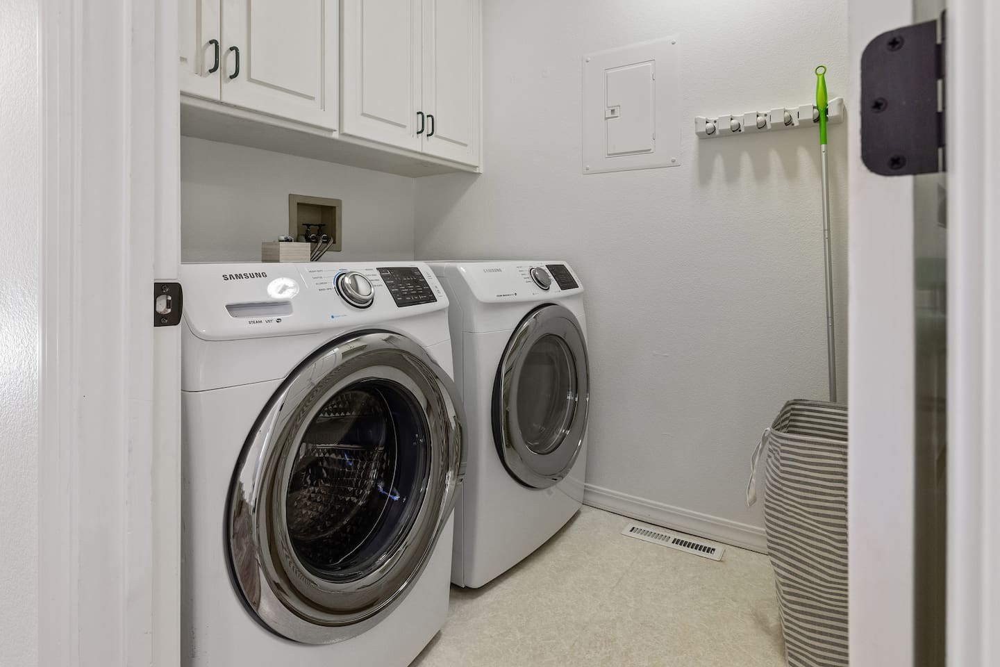 Full-size washer and dryer in the bedroom hall provided with laundry detergent for guest use.