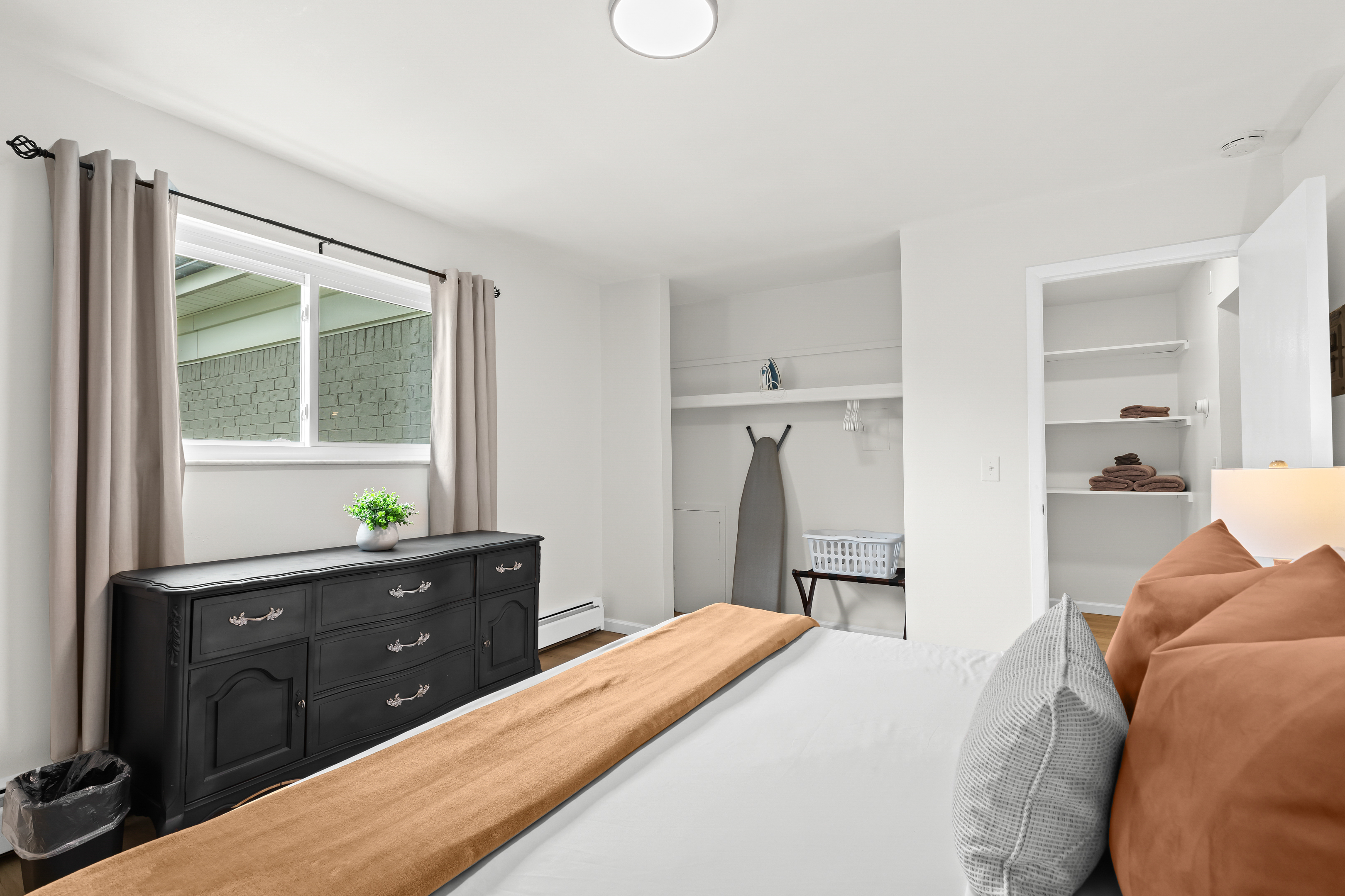 Bright and airy bedroom with ample storage, natural light, and thoughtful essentials for a relaxed and organized stay.
