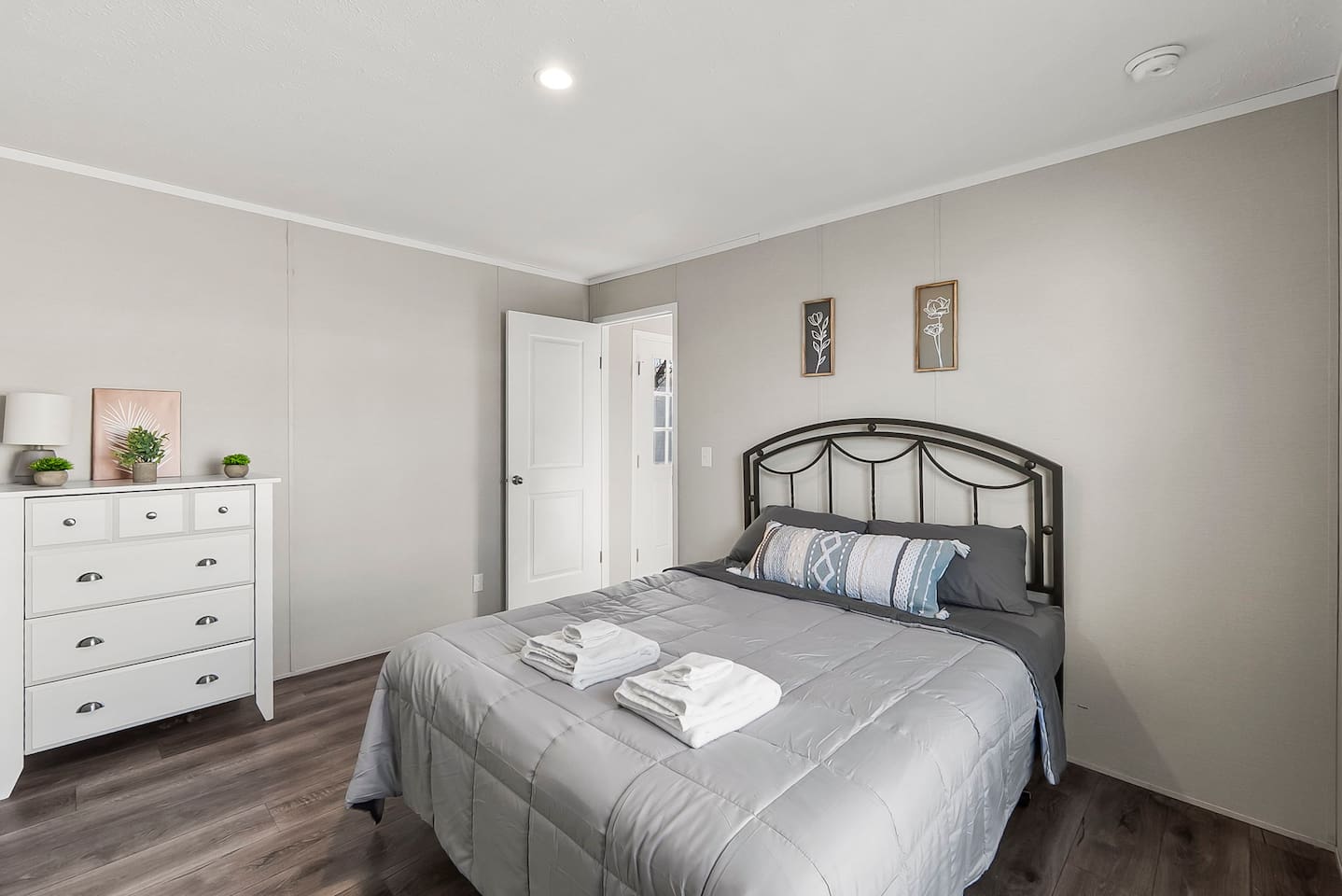 Cozy bedroom featuring a comfortable queen bed, soft linens, and a calming neutral design for a restful night’s sleep.