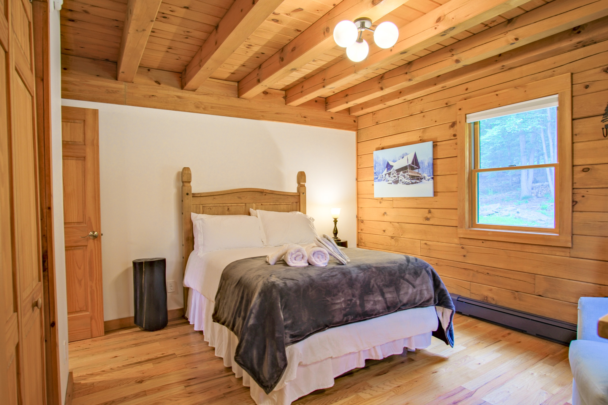 This first guest bedroom is equipped with a queen size bed, providing all the privacy you might need. This all-wood room creates the coziest feeling of a true cabin.
