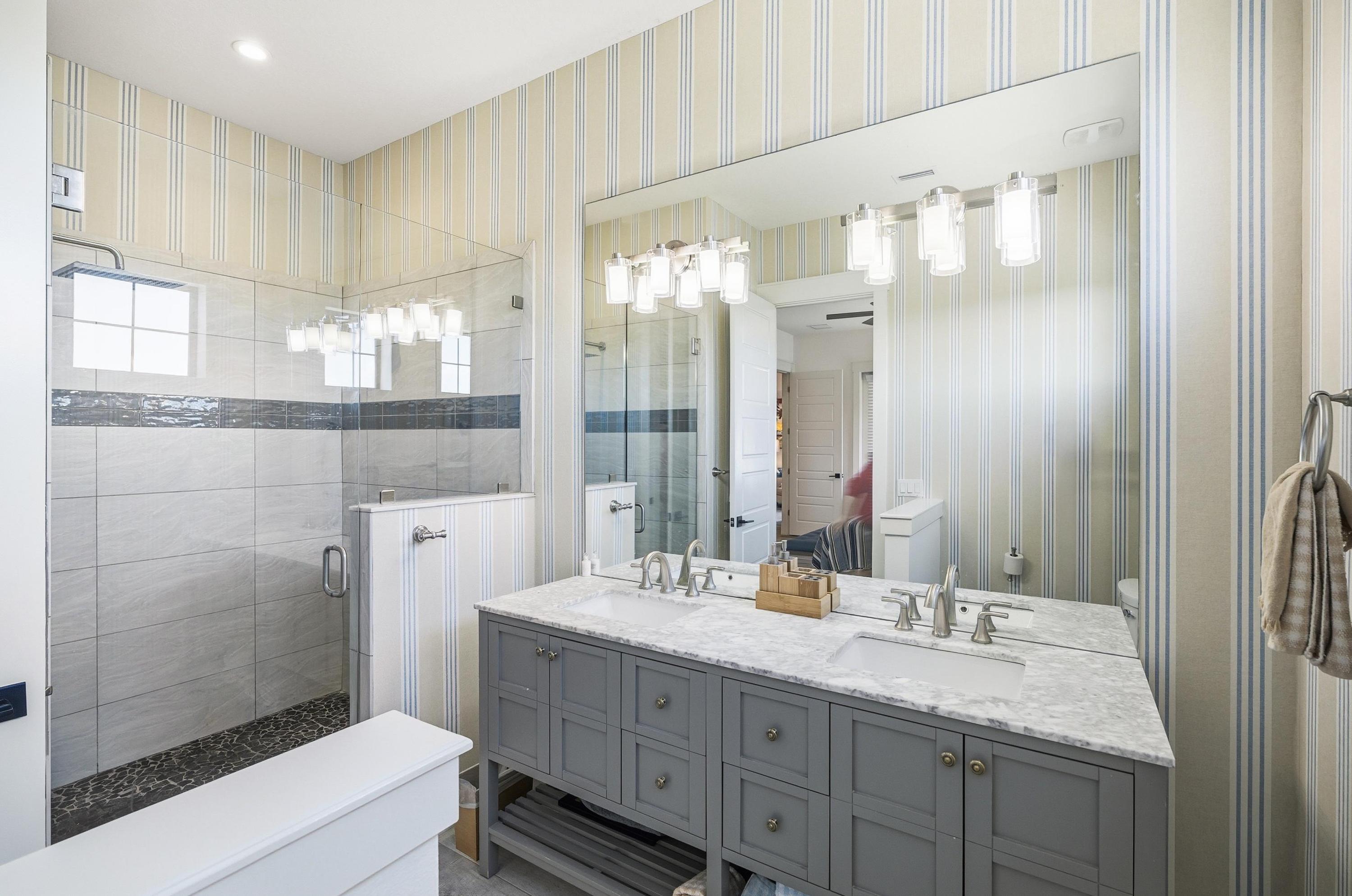 Spa-like mornings start here 🚿✨
This bright, coastal-chic bathroom features a double vanity, oversized mirror, and a sleek glass walk-in shower—perfect for rinsing off the beach and getting ready with ease.