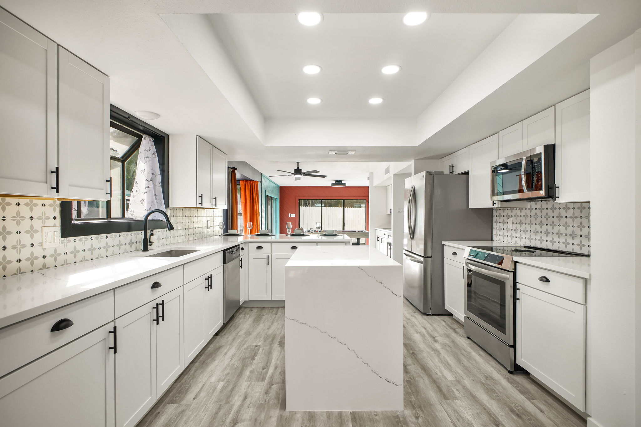 Full Kitchen: Bright open-concept kitchen with white cabinetry and quartz countertops. Southwest-inspired backsplash adds a stylish pop of design.