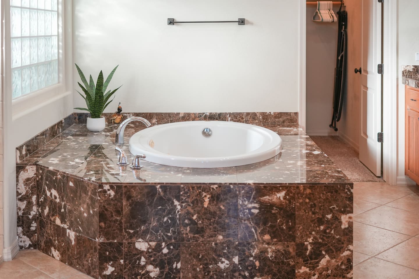 Spa-style soaking tub surrounded by marble-look stone, perfect for unwinding after a day out.