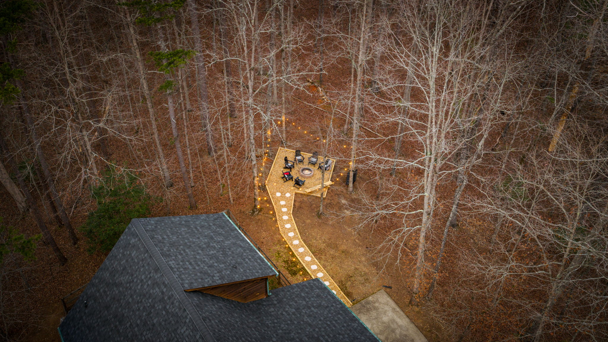 This stunning aerial view of the fire pit, captured by drone, showcases the layout of the outdoor space from above.