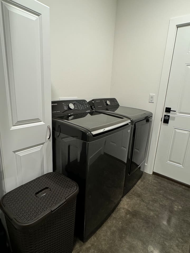 Laundry room with washer, dryer, including laundry soap, and cleaning supplies.