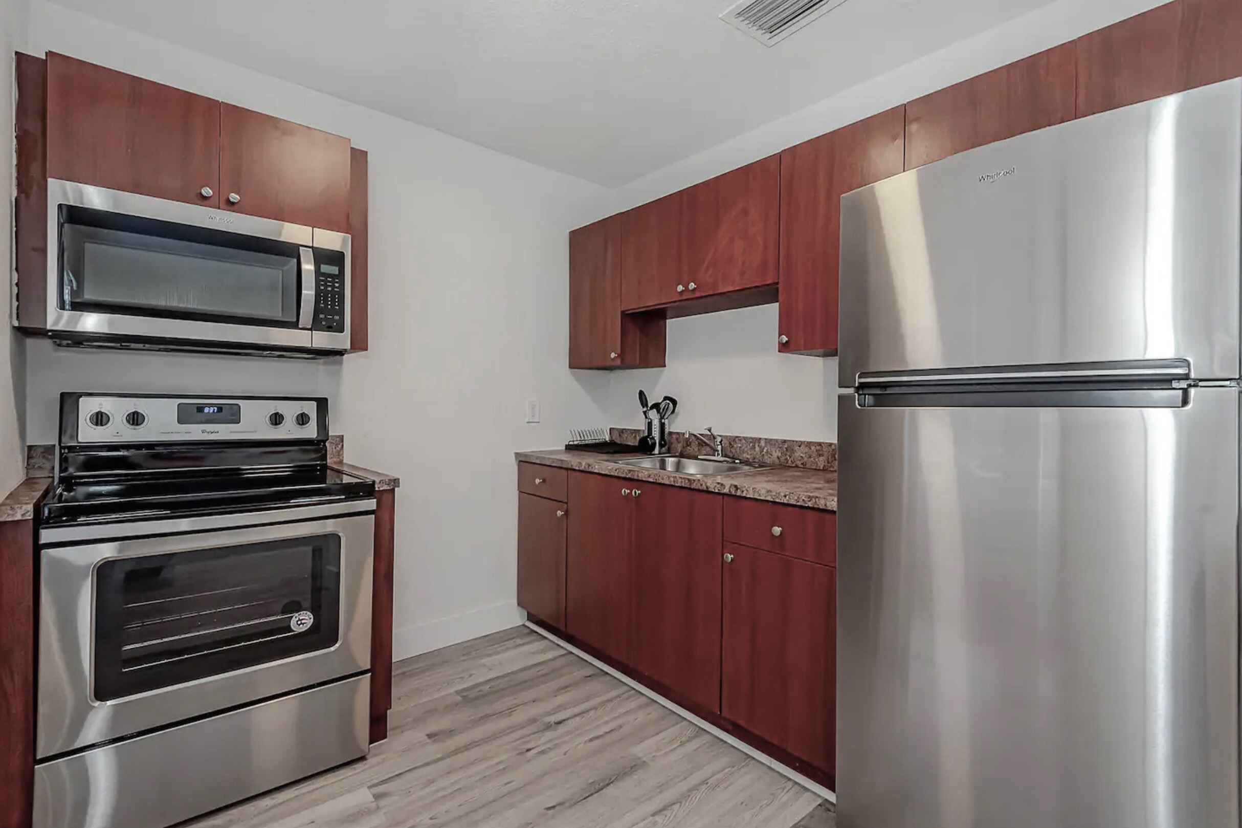 Fully stocked kitchen with stainless steel appliances.