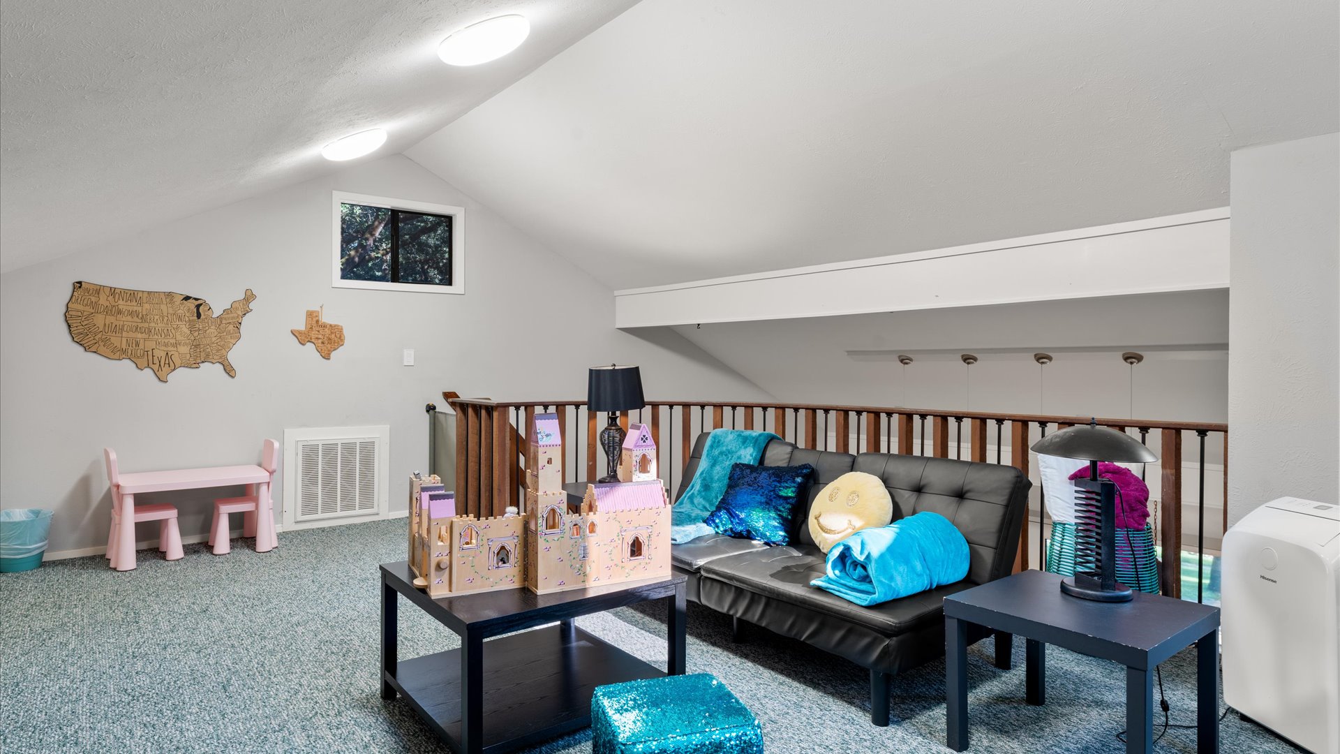 Cozy loft for families! Relax on the loveseat, lounge in bean bags, or let kids enjoy the play area with a dollhouse and table. A perfect spot for fun and relaxation!