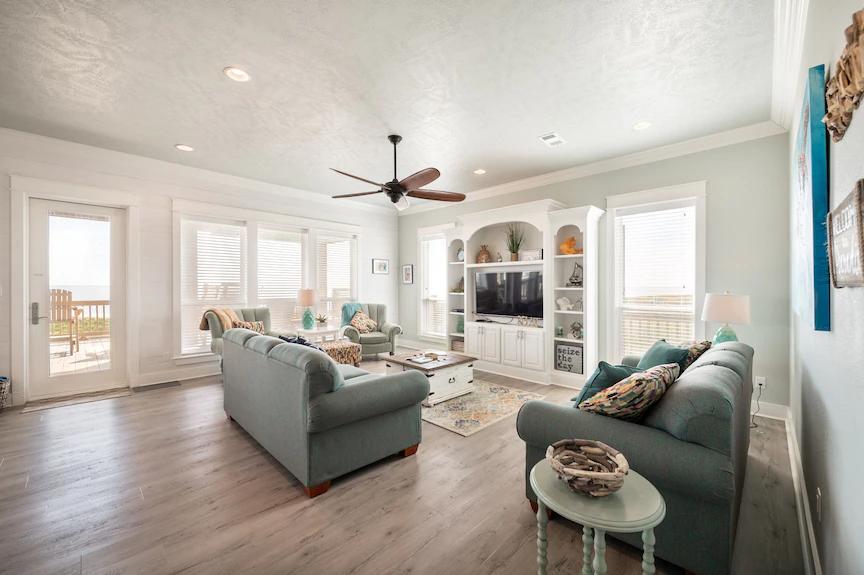 Designed for relaxation, this spacious living area features soft coastal tones, abundant natural light, and an open layout that makes it easy to socialize, lounge, and feel right at home.