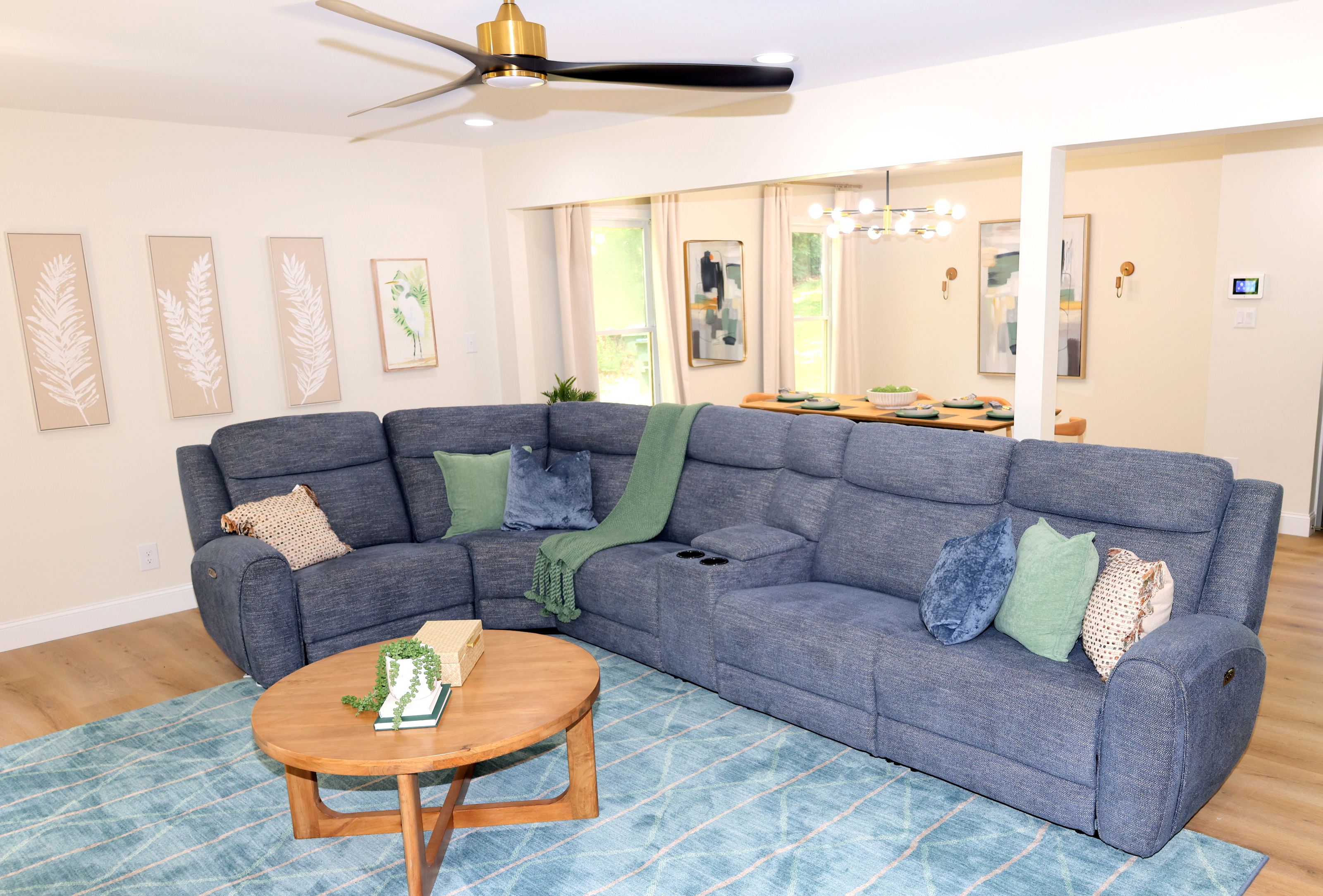 Comfortable main living room with large sectional, TV, and open access to the dining area