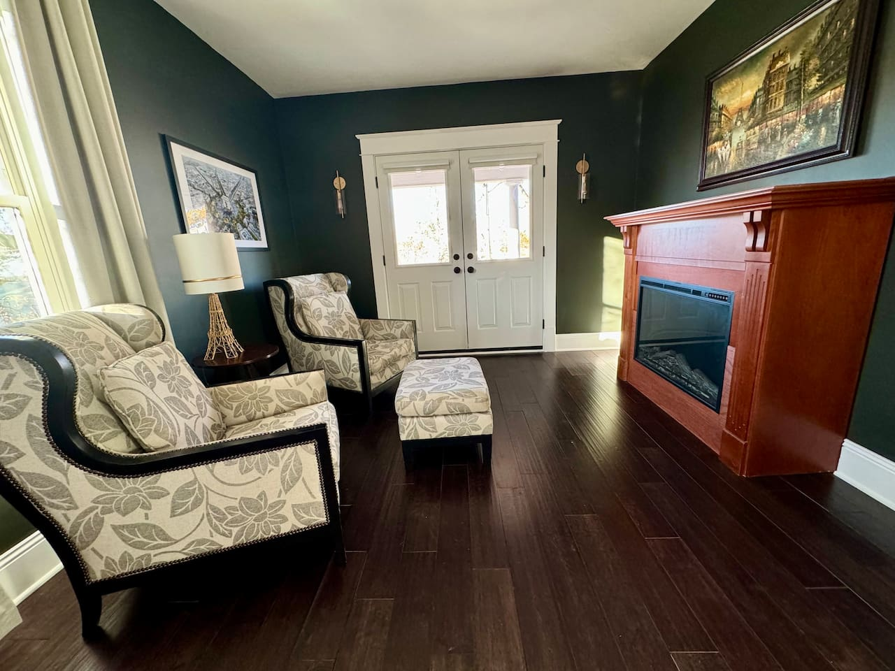 Electric fireplace, sitting room and access to covered balcony in the Paris Suite.
