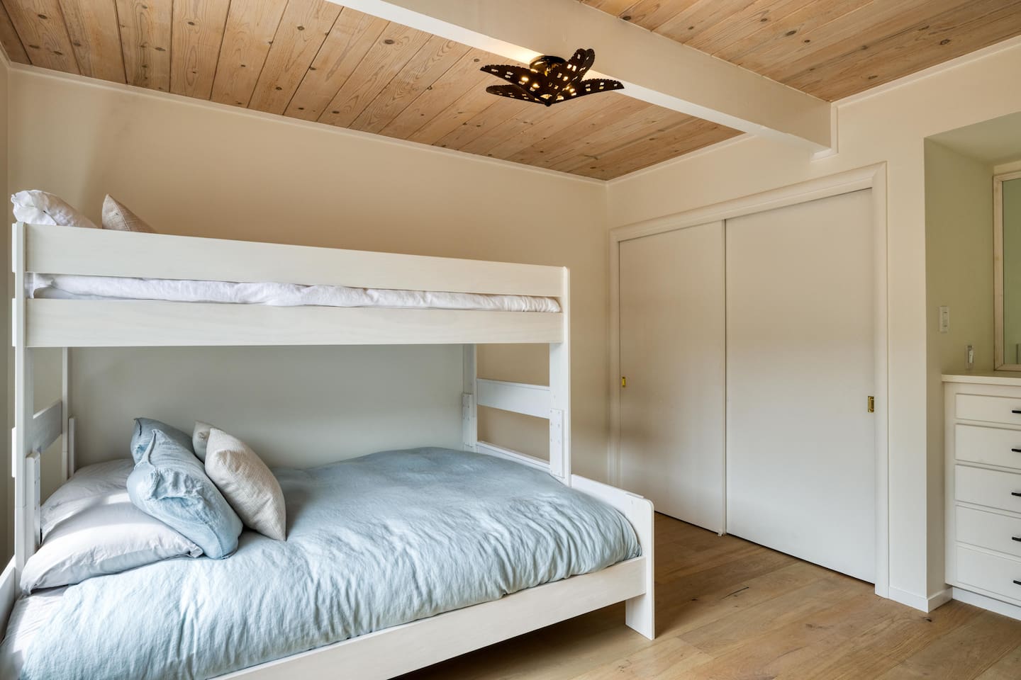 - Bunk bedroom with twin over full bed dressed in soft blue bedding  
- Wooden ceiling and white walls keep the space warm and inviting  
- Perfect for kids, friends, or additional guest accommodations  
