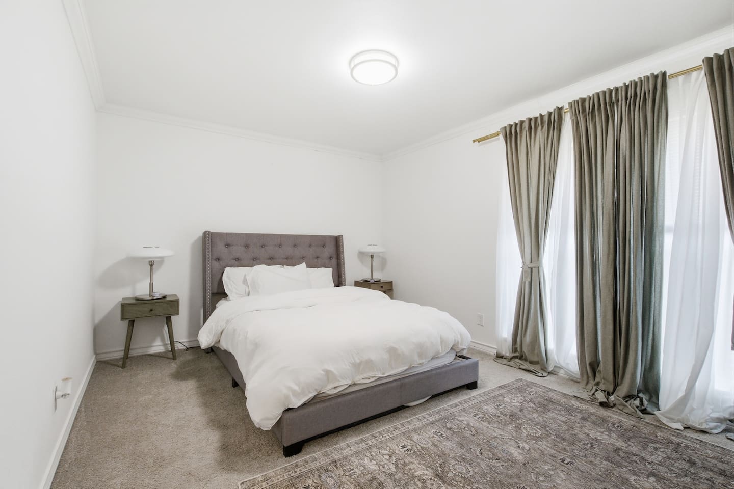 Primary bedroom with queen bed, TV, plush linens, room darkening shades, and calming natural light for restful nights.