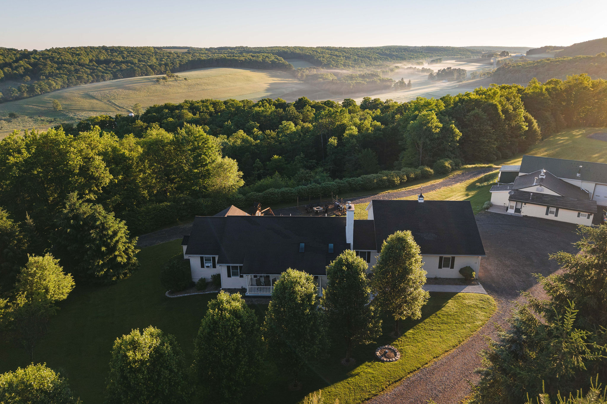 🌄 Hilltop seclusion — the farmhouse framed by forest.