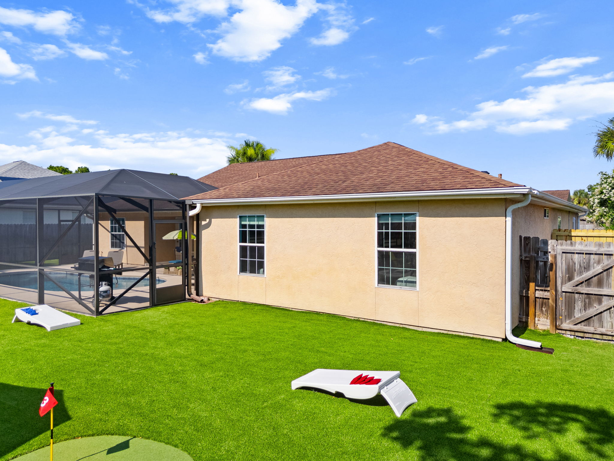 Toss some bean bags and relax! Our private backyard features a full cornhole game setup on beautiful artificial turf. Located beside the putting green and pool enclosure, it’s built for perfect afternoon entertainment.
