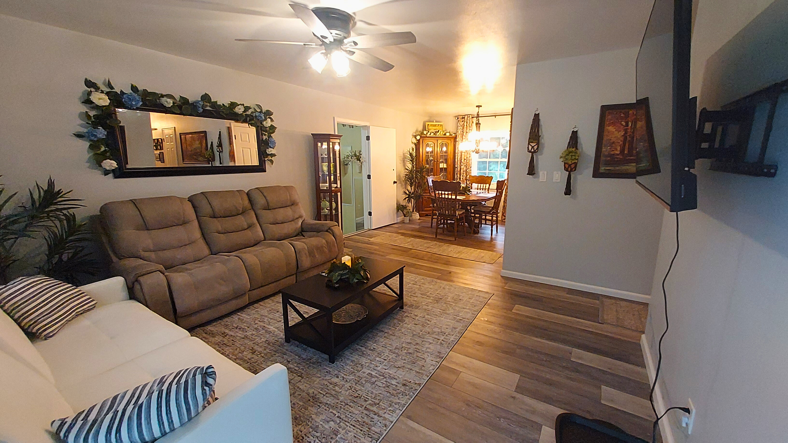 This cozy open living area features a coil-spring futon , a dual-powered sofa with adjustable headrests, leg rests, and built-in charging ports—all centered around a 55" TV for easy relaxation and the perfect spot to unwind after a long day.