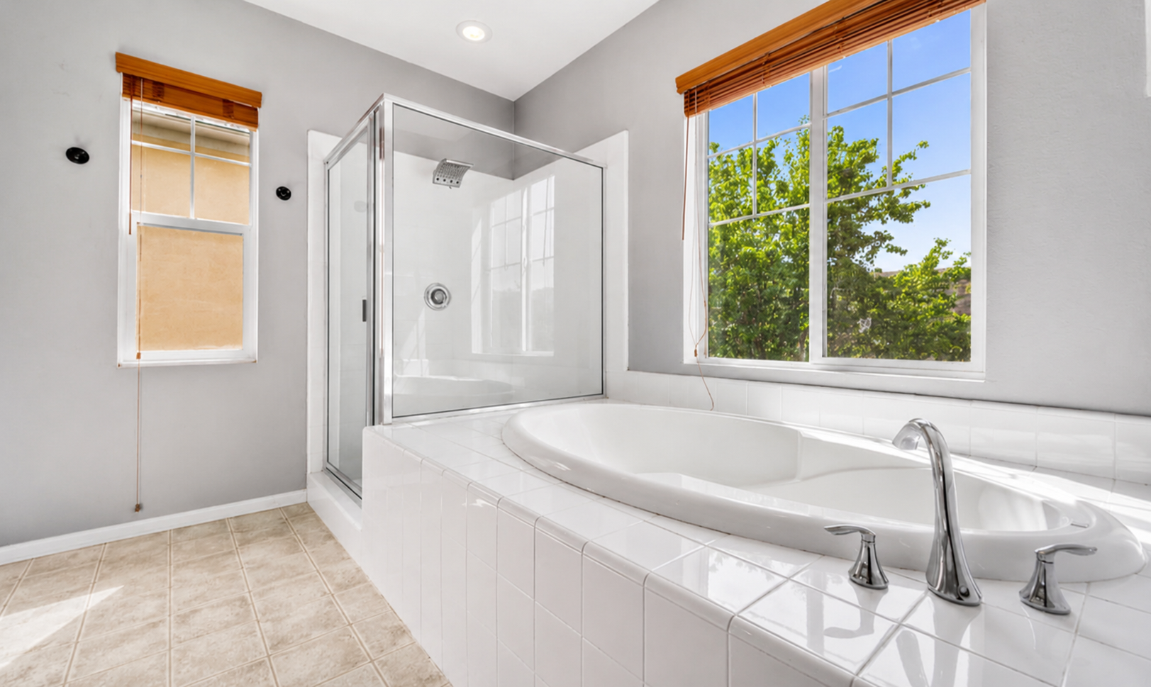 Bathroom with a soaking tub, glass shower, and sunny windows for a relaxing start or end to the day.