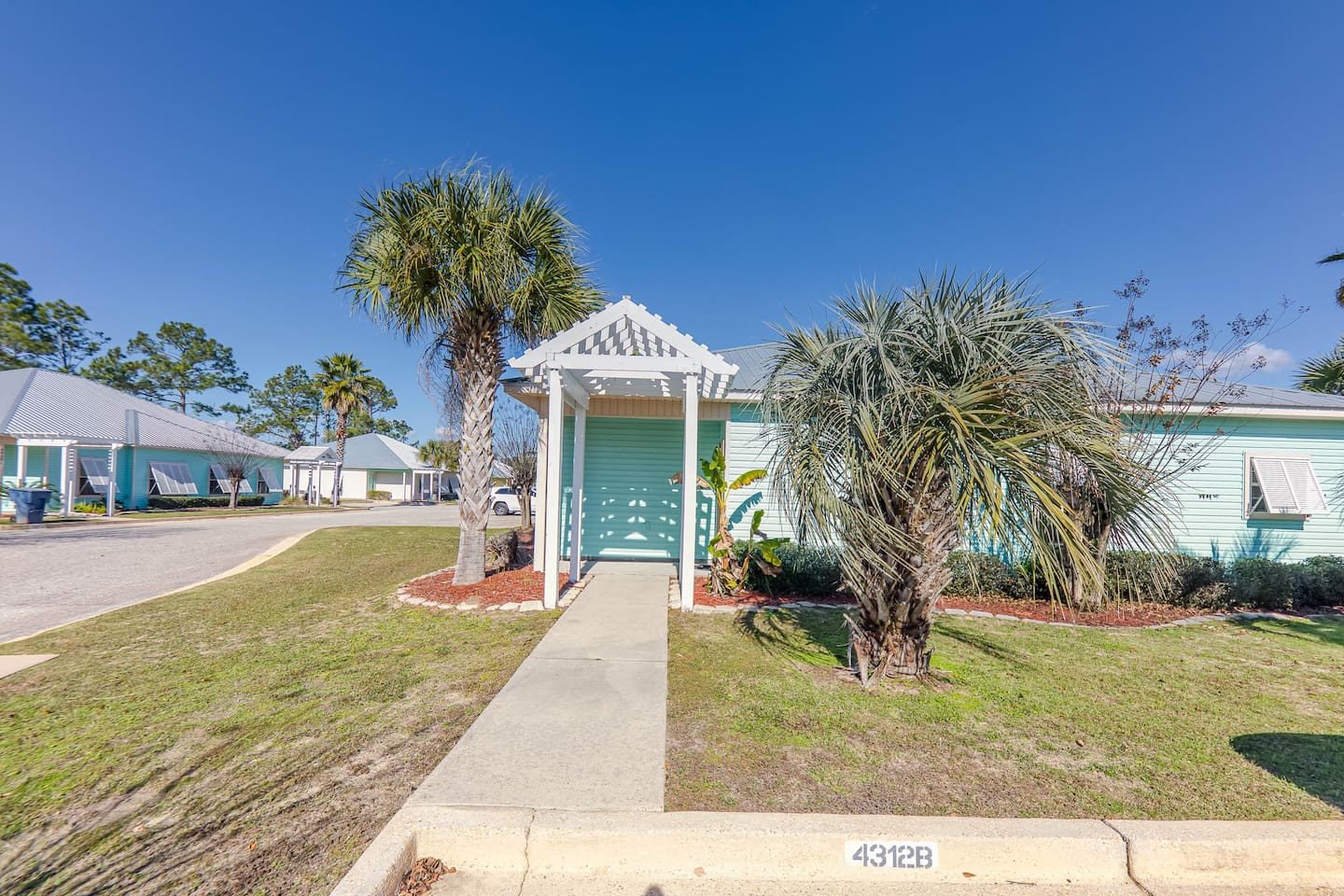Charming Entryway: Welcome to your beach escape! Enjoy palm-lined paths and vibrant coastal vibes.