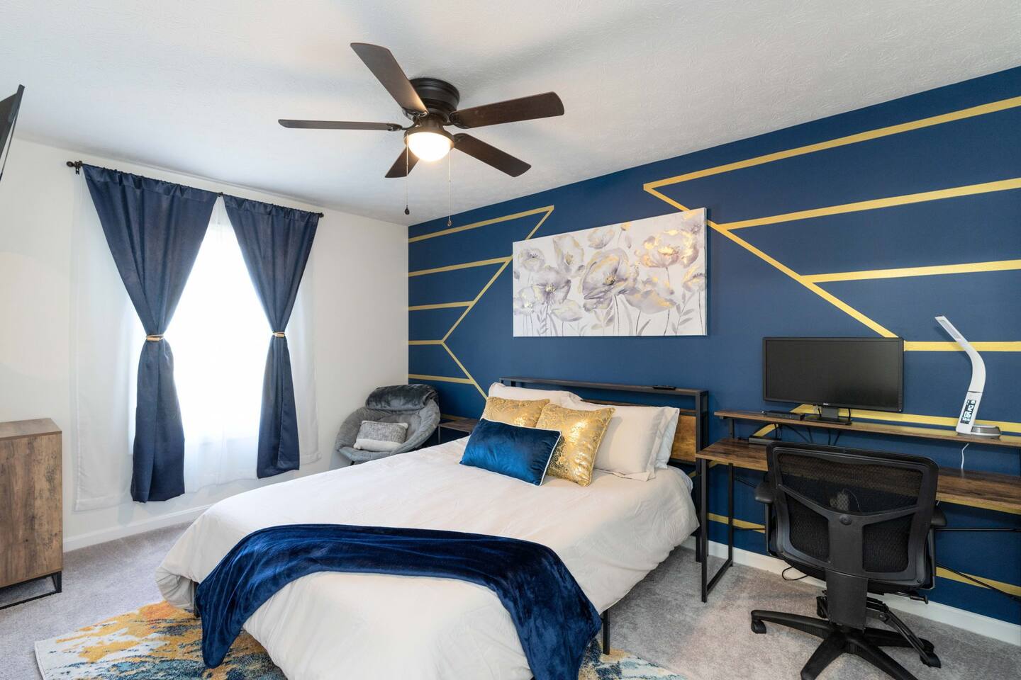 Secondary bedroom featuring queen bed, tv, and work space.