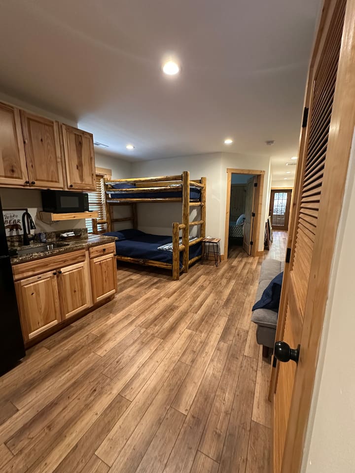 Lower level of the cabin with bunk bed & sofa
This area also has a sink, fridge, & cabinet space.