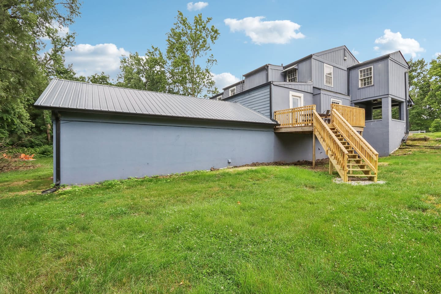 Enjoy the spacious grassy yard and easy access to the elevated deck—great for fresh air and relaxed outdoor time.