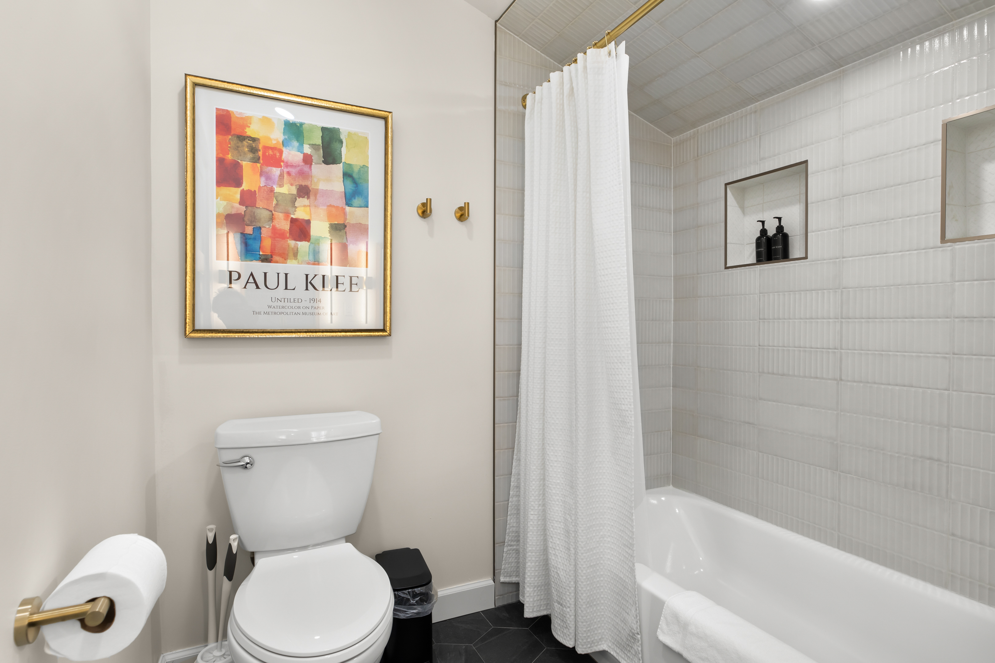 Clean and modern full bathroom with a tiled shower and bright decor.