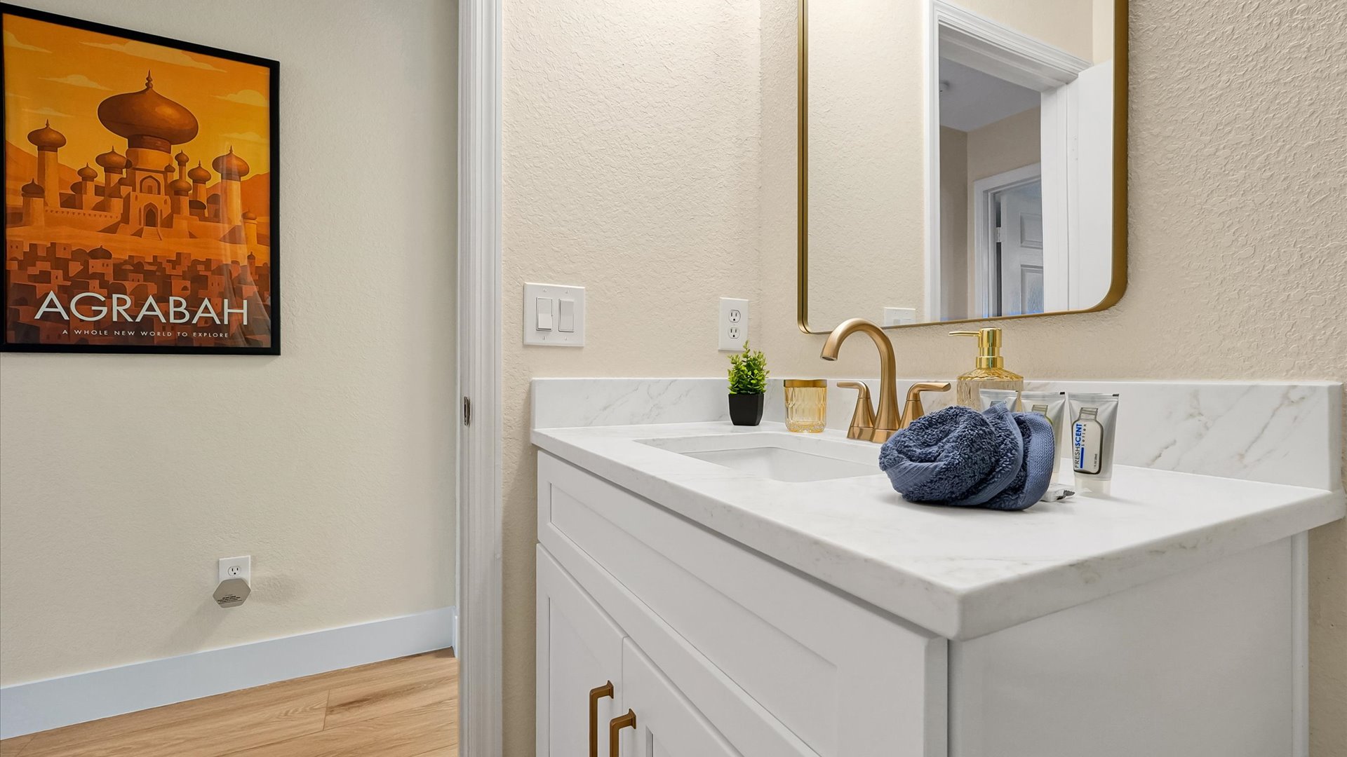 Aladdin King Suite Ensuite: Bright vanity with generous counter space, starter toiletries and Agrabah-inspired artwork.