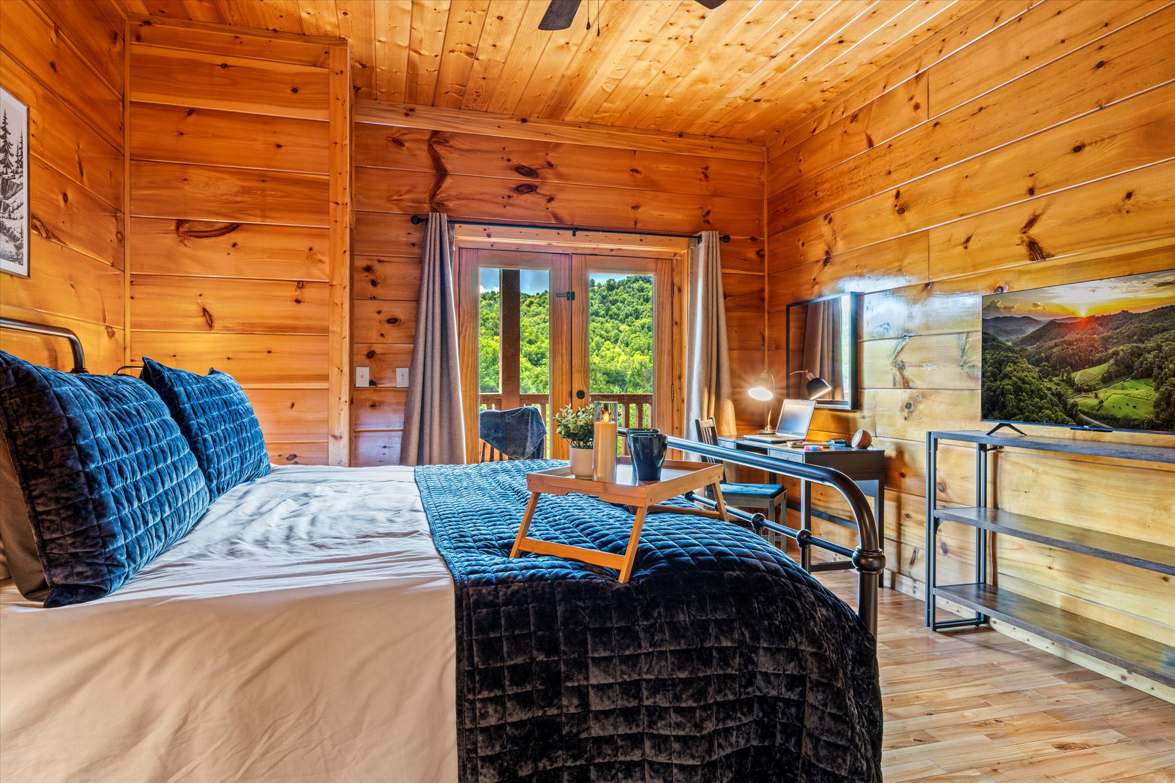 Cozy bedding and stunning views—step straight onto the lower-level deck from this spacious bedroom.