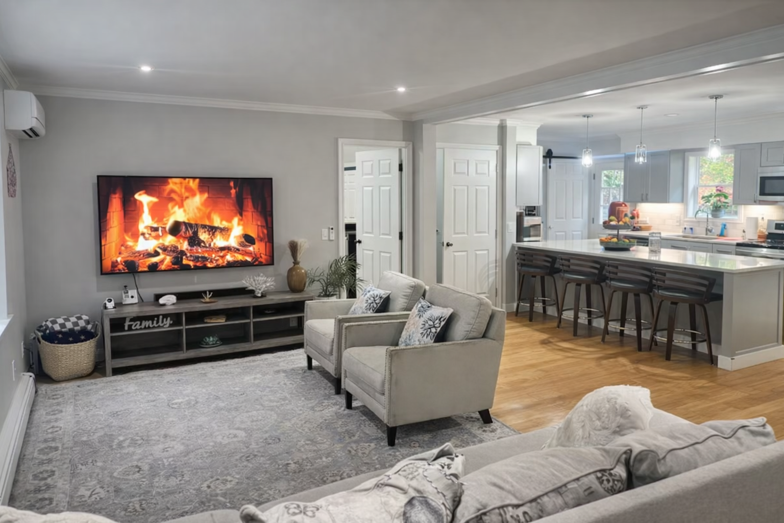 Open-plan main level living area with large TV and fireplace