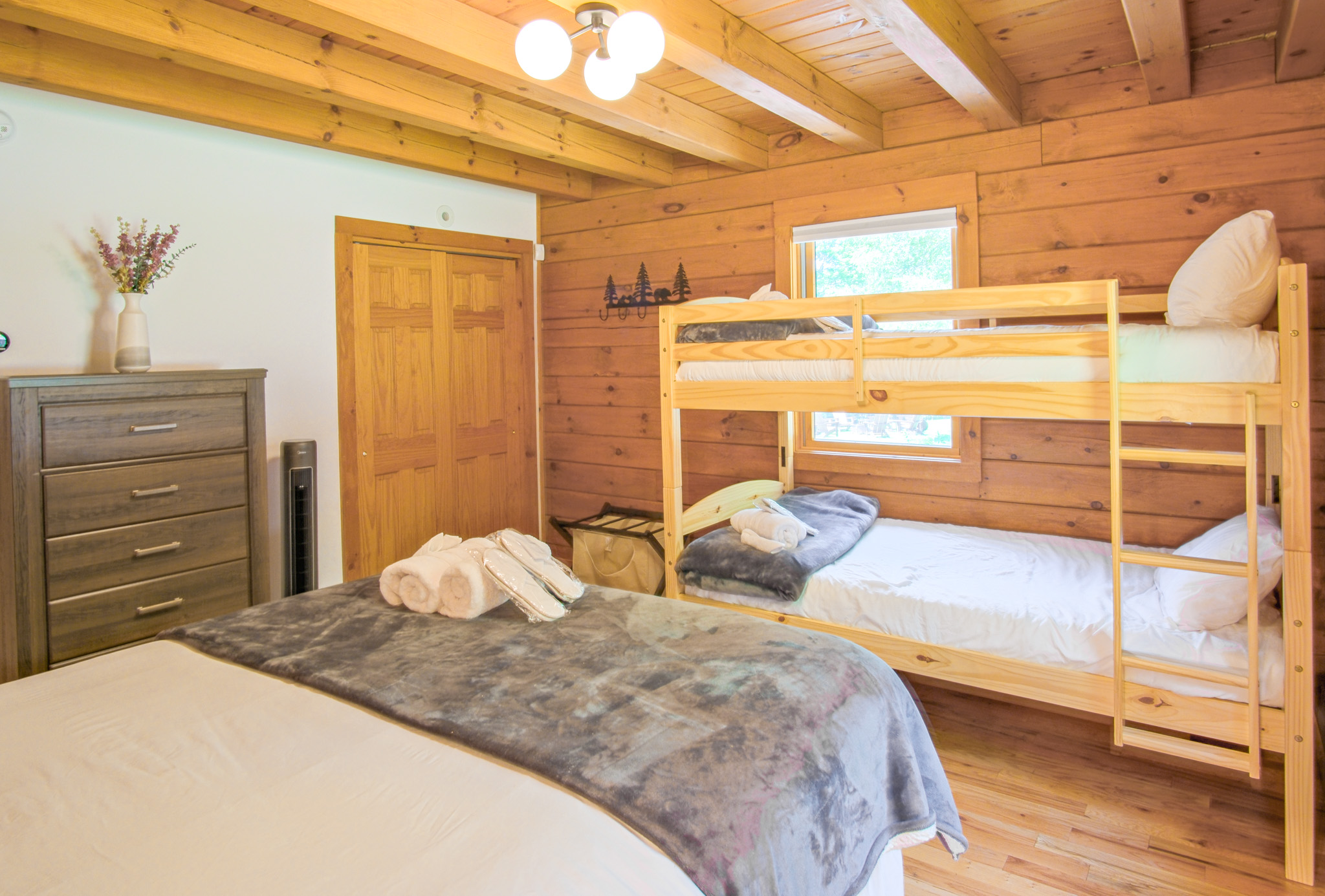 Offering a full size bed and a set of twin bunk beds, this second guest bedroom is perfect for a family, blending coziness and luxurious feel