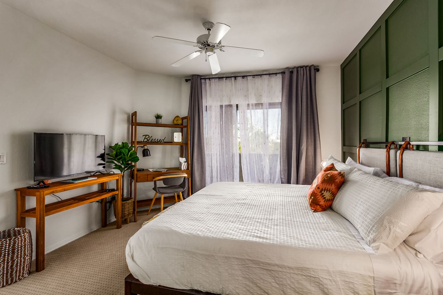 Spacious bedroom with king bed, workspace, and simple storage for short or extended stays.
