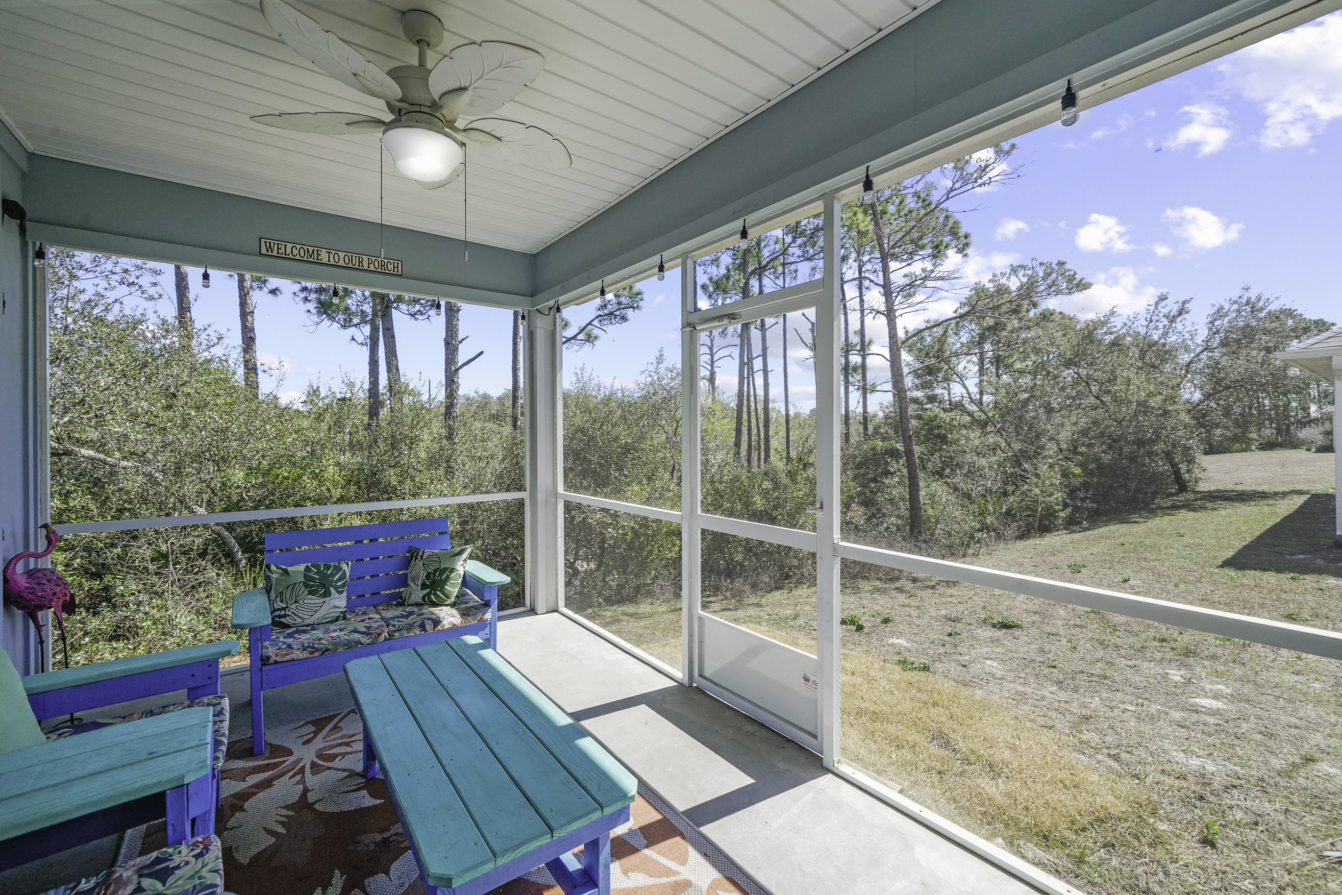 Screened porch with outdoor seating and ceiling fan
