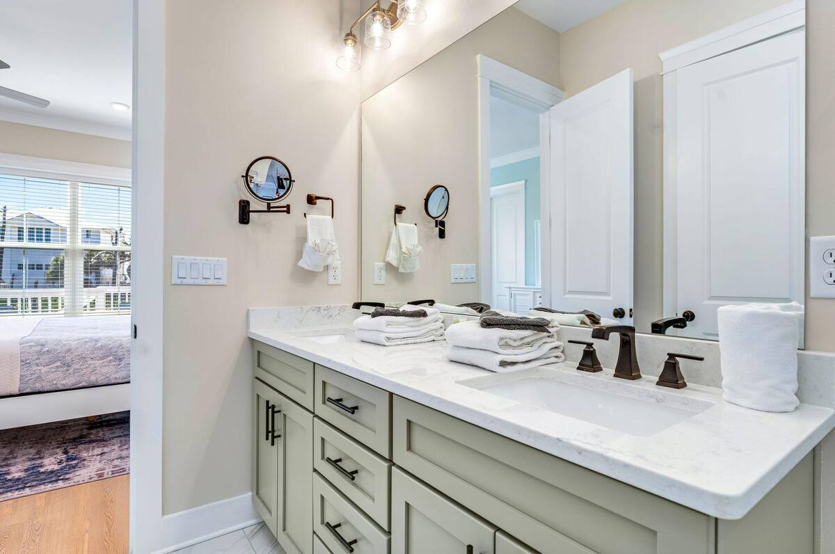 Elegant primary bath with a double vanity, rich finishes, and direct access to the serene king suite for ultimate comfort and convenience.