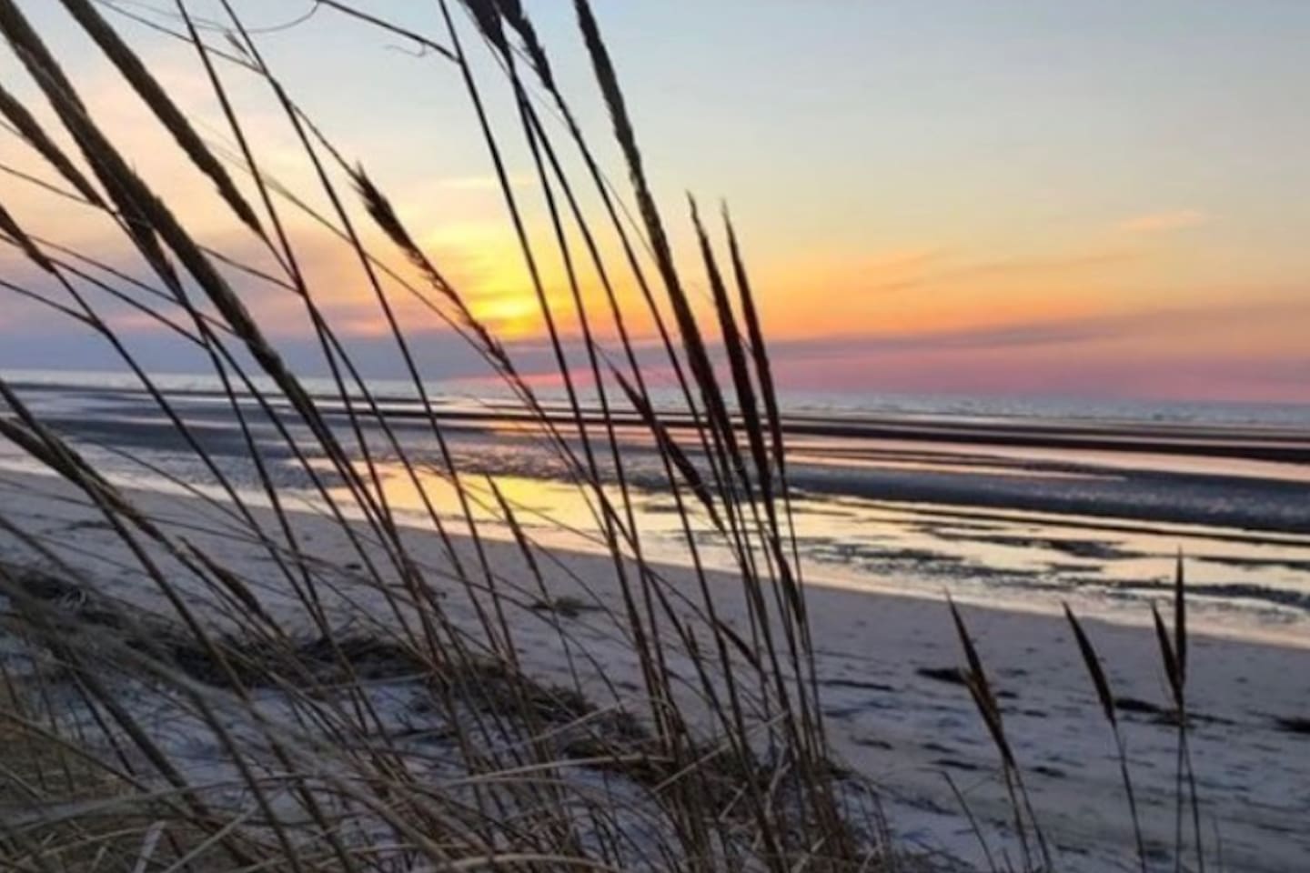 Relax and take in the view through the swaying sea grass. The dunes offer a front-row seat to spectacular sunsets, where the sky turns brilliant shades of orange and pink over the quiet, tide-washed shore.