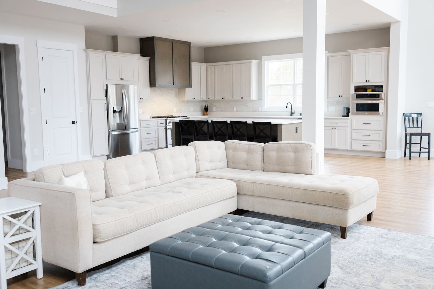 Spacious living room is open to the kitchen and second floor balcony. Master bedroom and library are just off the living room. Two stories of deck space are accessible out the doors by the fireplace opposite the couch. 85" TV.