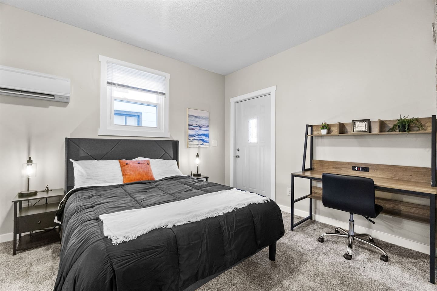 Cozy bedroom featuring a comfortable bed and a convenient desk for work or study.